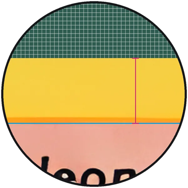 Magnified top border of a real card, a 1999 Pokémon Base Set Charizard: the cyan line sits on the inner edge of the yellow printed border, and a magenta bracket spans the border from the cut edge